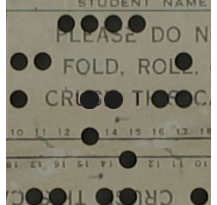 Computer punch card with round holes.