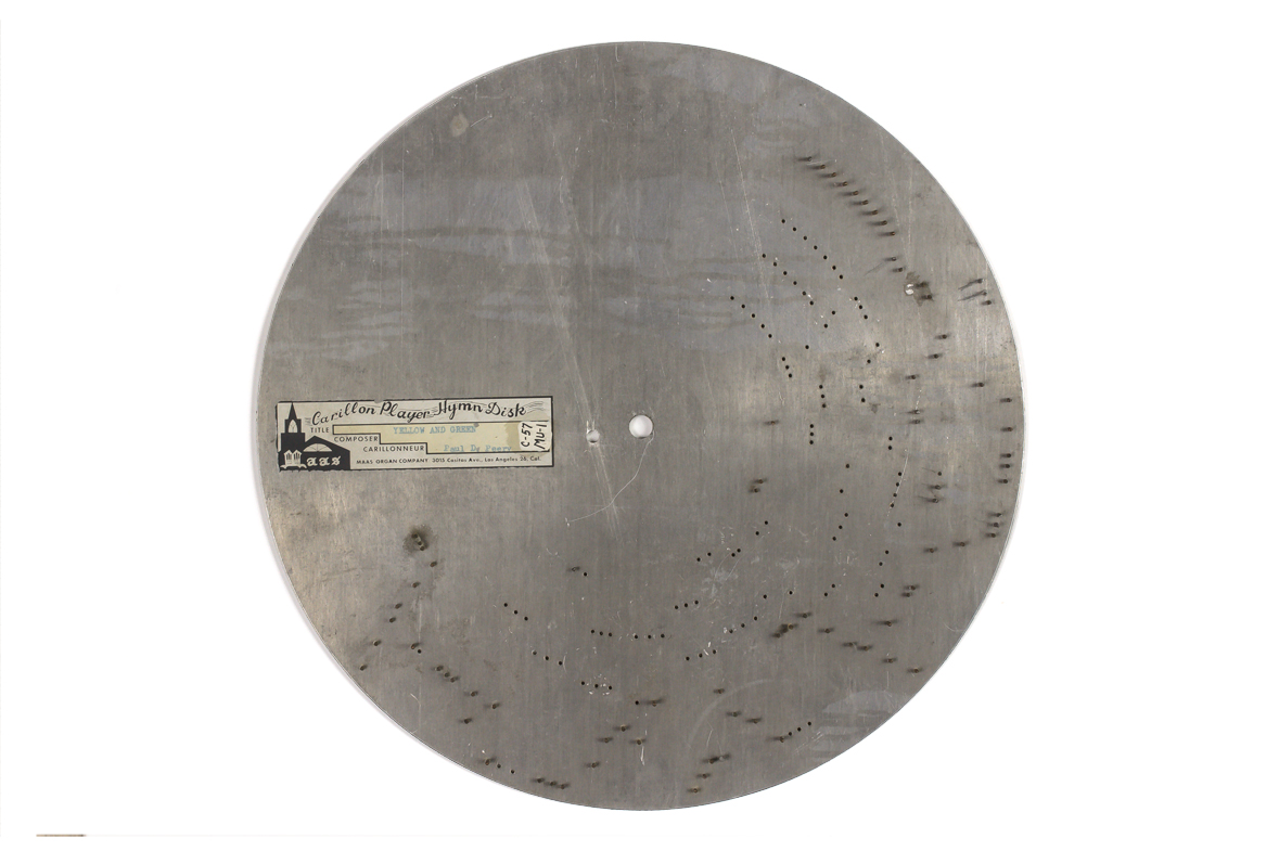 Heavy steel disc with metal pins set into face for Maas-Rowe Carillon Player, song title on label is Yellow and Green