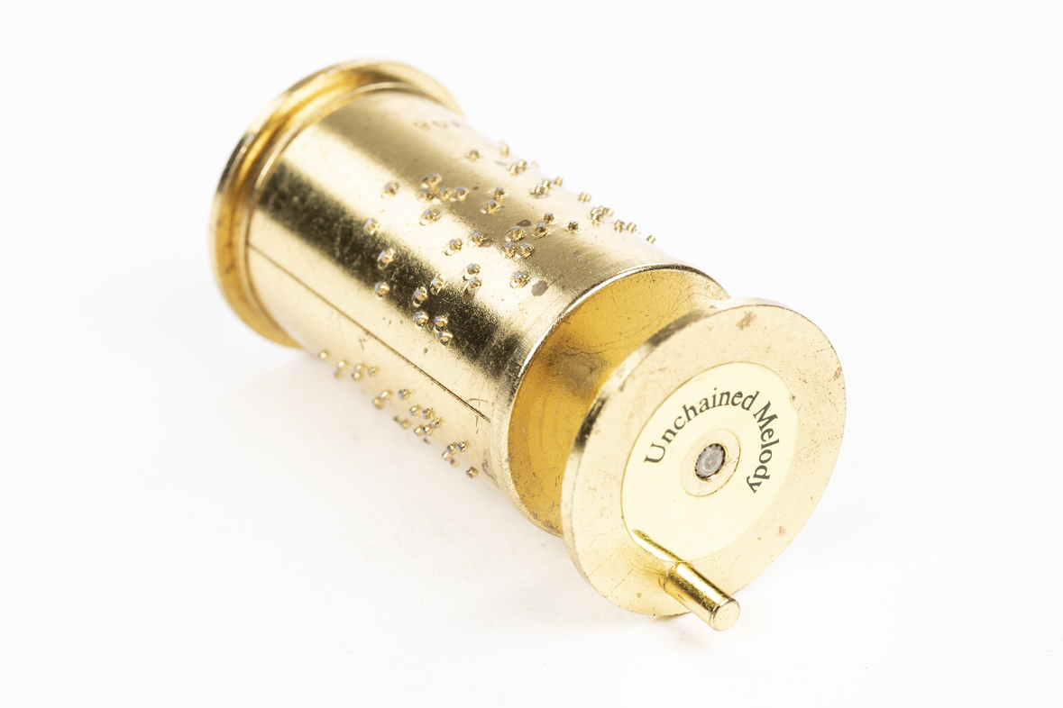 Tiny brass-colored metal music box cylinder for the Musical Melodium