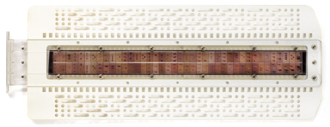 Images in a film strip mounted in a plastic frame punched with various holes that provide the answer key