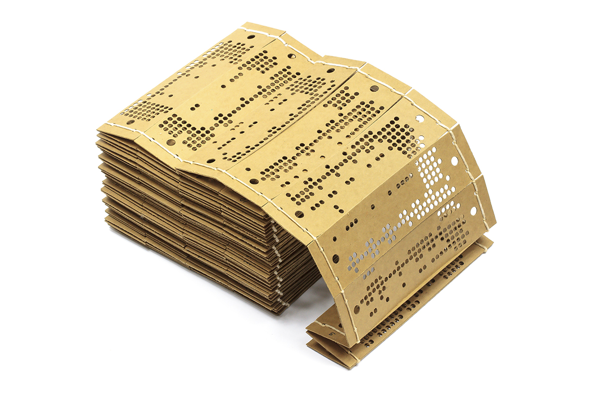 A stack of cards for a Jacquard loom punched with holes in rows and strung together with string