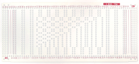 A sheet of flexible plastic punched with holes in a pattern for a knitting machine